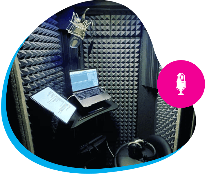 A laptop and microphone in a recording booth.